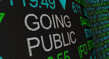 Digital text on a screen displaying stock prices and the words 'GOING PUBLIC'.