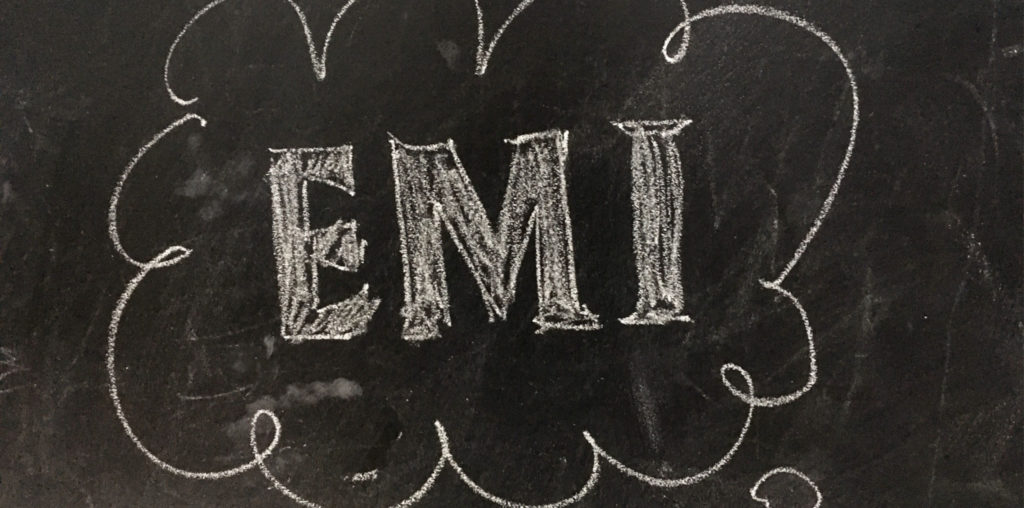 Blackboard with the letters EMI witten in white chalk.