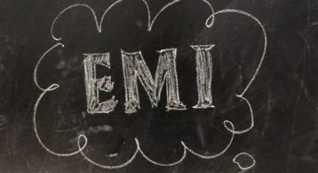 Blackboard with the letters EMI witten in white chalk.