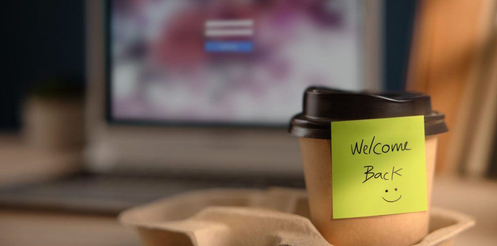 Close-up of a Welcome Back note on a takeaway coffee cup on an office desk. Concept of company coming back to life through administrative restoration.