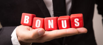 Businessman holding 5 red cubes spelling the word 'BONUS' on the palm of his hand.